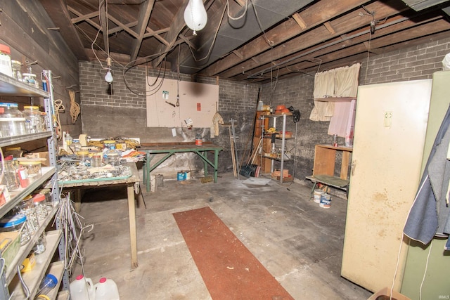 unfinished below grade area with brick wall and a workshop area