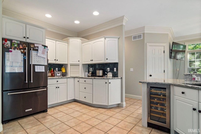 kitchen with backsplash, black refrigerator, white cabinets, and wine cooler