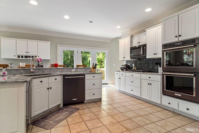 kitchen with dishwasher, sink, double wall oven, white cabinets, and light tile patterned flooring