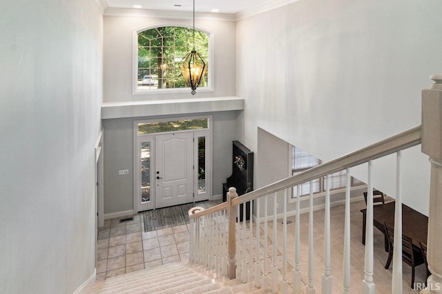 tiled entryway featuring crown molding