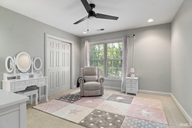 living area with ceiling fan and light carpet