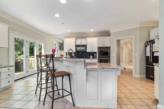 kitchen featuring white cabinets, tasteful backsplash, black appliances, and light tile patterned flooring