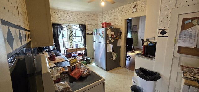 kitchen featuring ceiling fan, light wood-type flooring, and stainless steel refrigerator