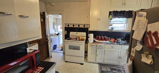 kitchen featuring white electric stove, decorative backsplash, light tile patterned floors, fridge, and white cabinets