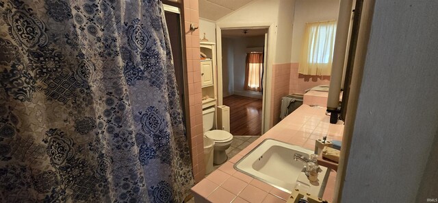 bathroom with hardwood / wood-style flooring, vanity, tile walls, and toilet