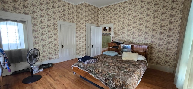 bedroom with ornamental molding and wood-type flooring