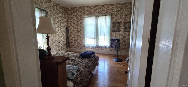 bedroom with hardwood / wood-style flooring and crown molding