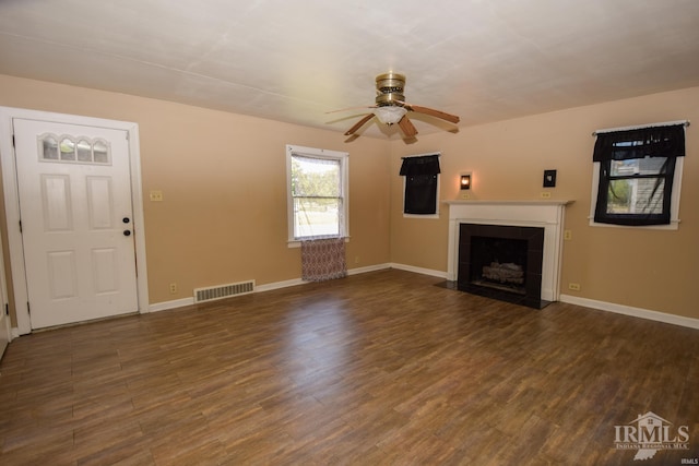 unfurnished living room featuring ceiling fan and dark hardwood / wood-style flooring