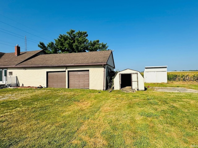 view of side of home with a storage unit, a garage, and a lawn