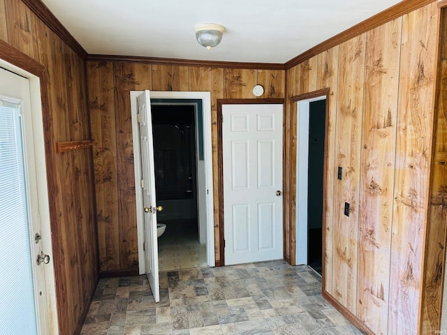 interior space with wooden walls, connected bathroom, and tile patterned floors