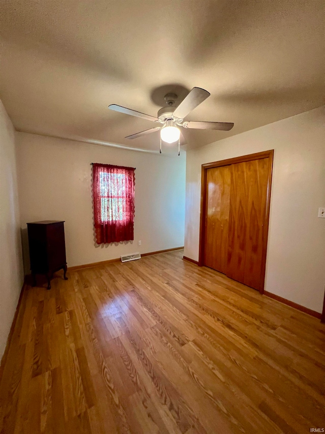 unfurnished bedroom with a closet, ceiling fan, and wood-type flooring