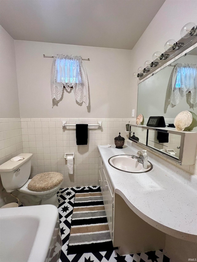 bathroom featuring tile walls, vanity, tile patterned floors, and toilet