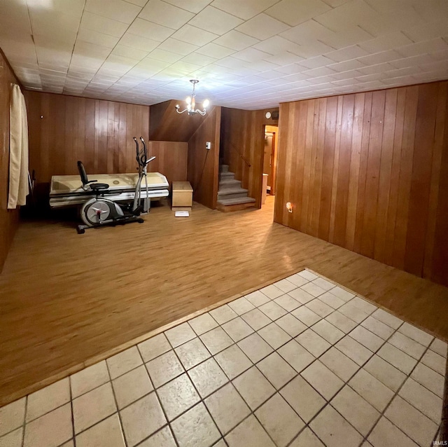 interior space featuring wooden walls, an inviting chandelier, and wood-type flooring