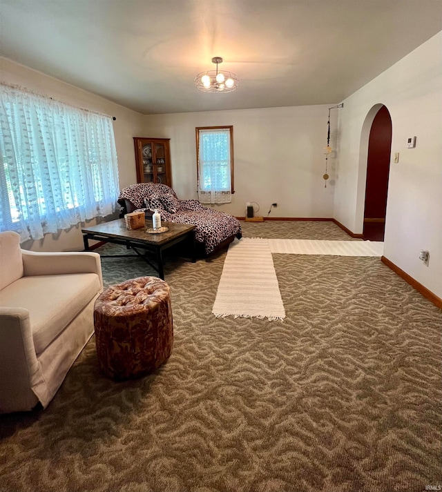 carpeted living room featuring an inviting chandelier