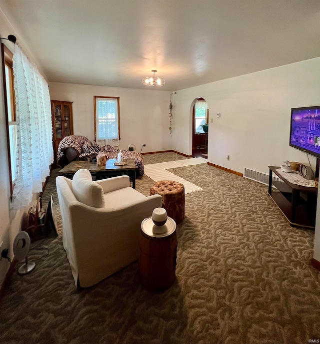 carpeted living room featuring a chandelier