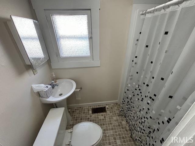 bathroom with sink, toilet, walk in shower, and tile patterned flooring