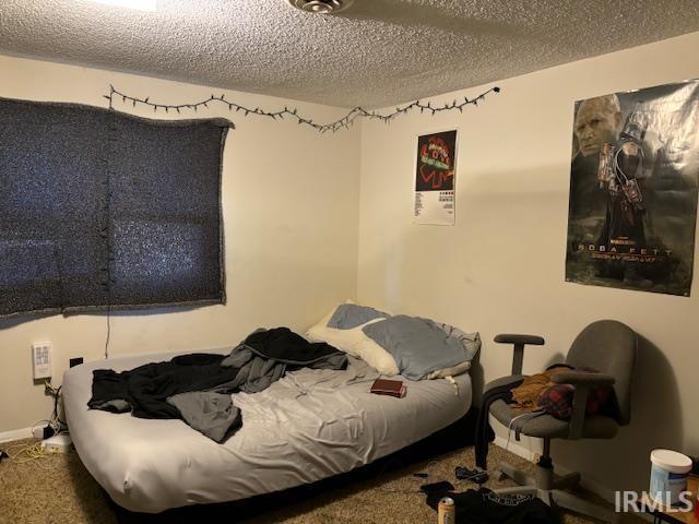 bedroom featuring a textured ceiling and carpet flooring