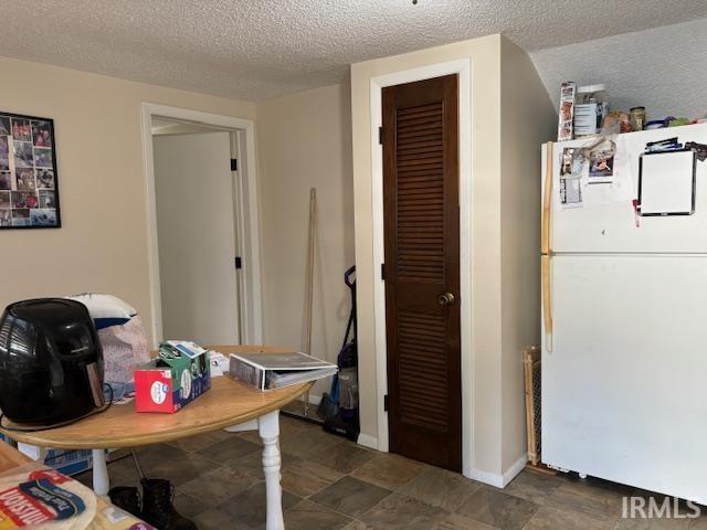 interior space featuring baseboards and a textured ceiling