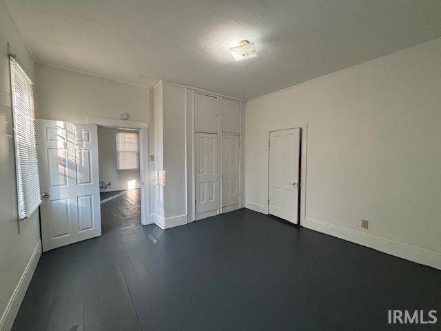 unfurnished bedroom featuring a closet and dark hardwood / wood-style floors