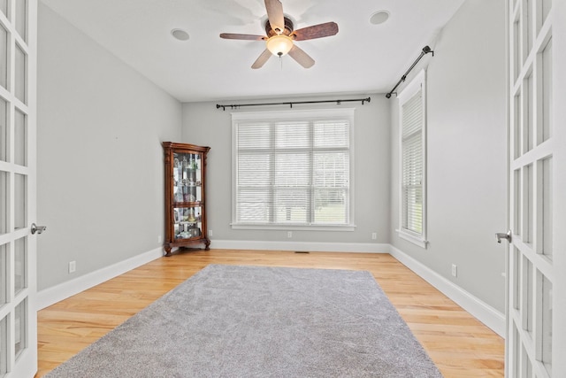 spare room with a ceiling fan, baseboards, french doors, and wood finished floors