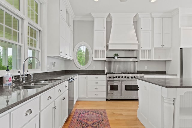 kitchen featuring a sink, open shelves, white cabinetry, appliances with stainless steel finishes, and custom range hood
