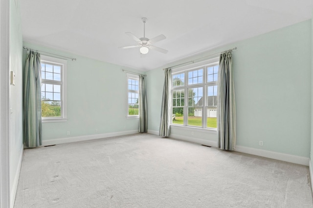 carpeted empty room with plenty of natural light, baseboards, and a ceiling fan
