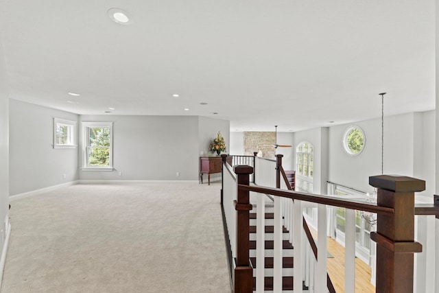 hall featuring light carpet, baseboards, an upstairs landing, and recessed lighting