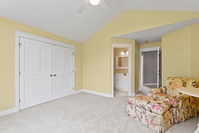 bedroom with a ceiling fan, a closet, baseboards, light carpet, and lofted ceiling