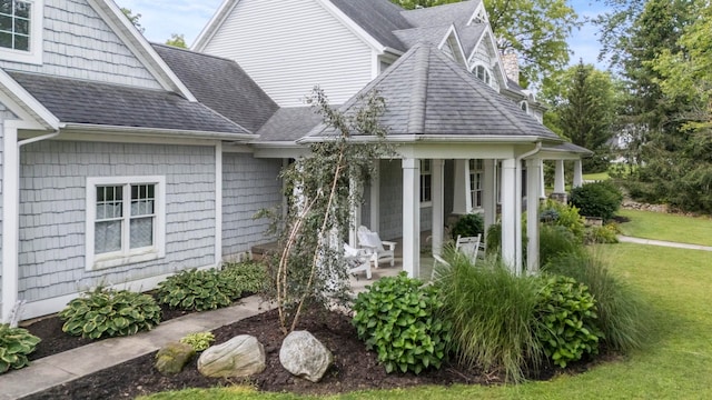 view of property exterior with a yard, roof with shingles, and a patio