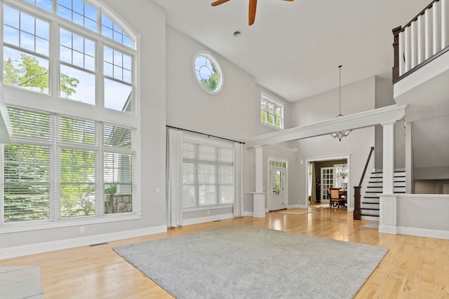 foyer with a ceiling fan, baseboards, plenty of natural light, and a high ceiling