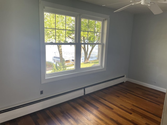 11585 E 565 N, Orland, IN 46776 - unfurnished room with baseboards, dark wood-style flooring, baseboard heating, and ceiling fan