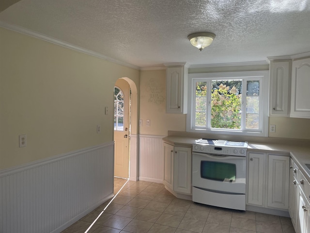 11585 E 565 N, Orland, IN 46776 - kitchen featuring white electric range oven, wainscoting, arched walkways, light countertops, and light tile patterned flooring