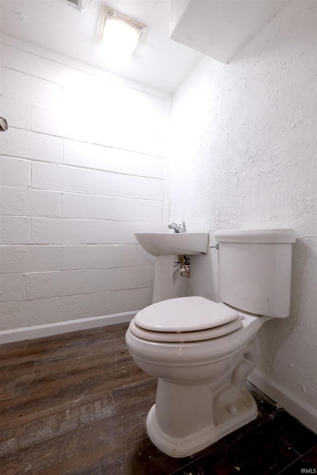 bathroom with hardwood / wood-style flooring and toilet