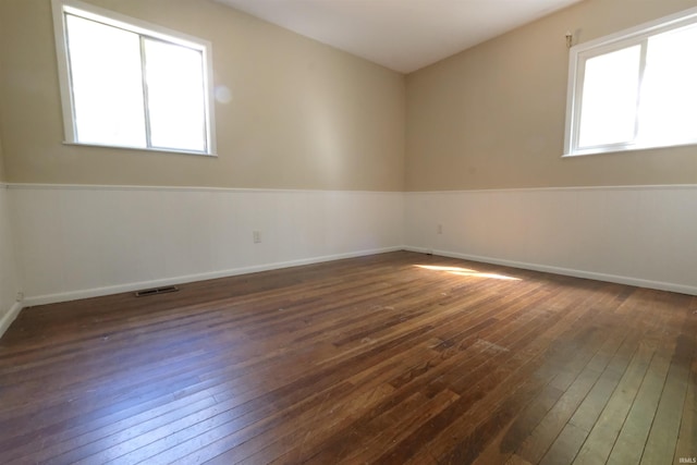 unfurnished room with dark wood-type flooring and a healthy amount of sunlight