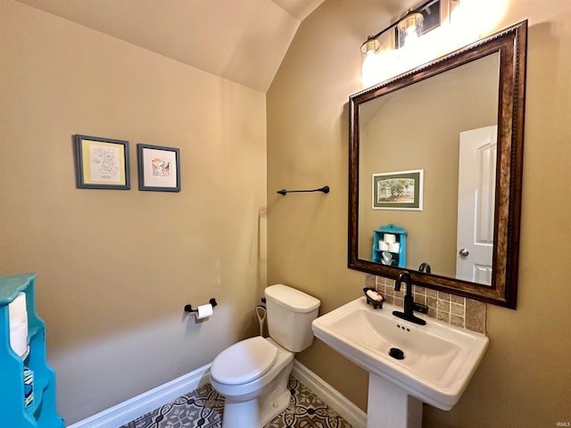 bathroom featuring sink, vaulted ceiling, tasteful backsplash, tile patterned flooring, and toilet