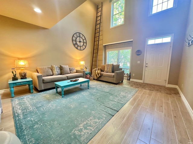 living room featuring light wood-type flooring and a high ceiling