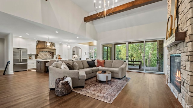 living room with high vaulted ceiling, dark wood-type flooring, a stone fireplace, and beamed ceiling