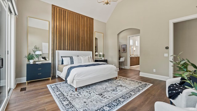 bedroom with dark hardwood / wood-style floors, high vaulted ceiling, and ensuite bathroom