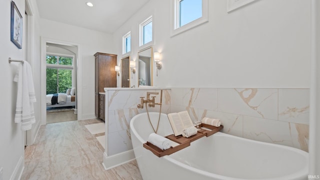 bathroom with a bath, tile patterned floors, vanity, and tile walls