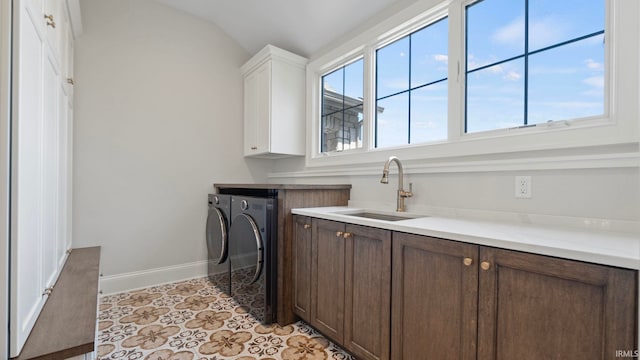 laundry area featuring sink, light tile patterned floors, cabinets, and washing machine and clothes dryer