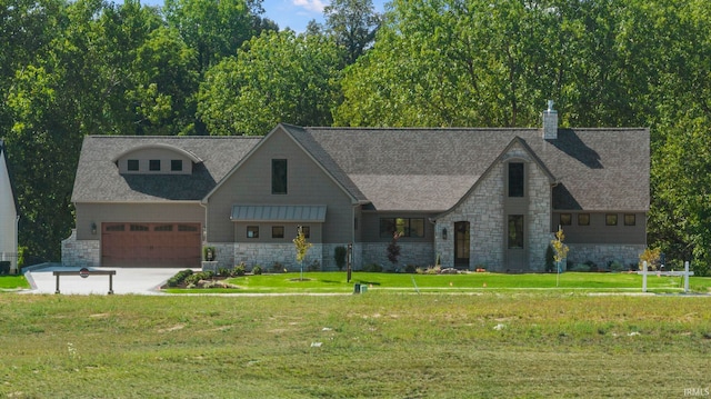 view of front of property with a garage, stone siding, driveway, and a front lawn