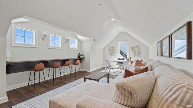 living area with lofted ceiling, a textured ceiling, recessed lighting, baseboards, and dark wood finished floors