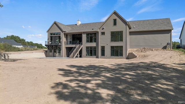 rear view of property with stairs and a deck