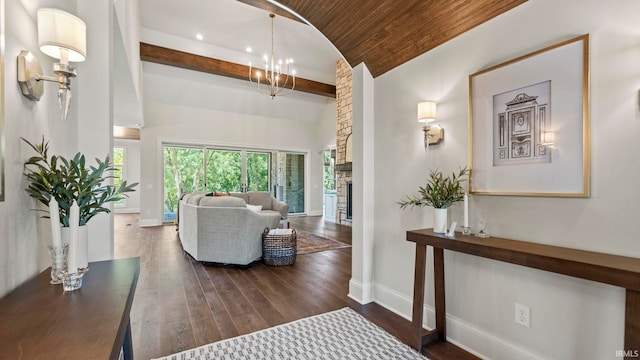 interior space with vaulted ceiling with beams, wooden ceiling, dark wood finished floors, and baseboards