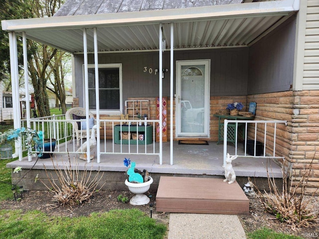 view of exterior entry with covered porch