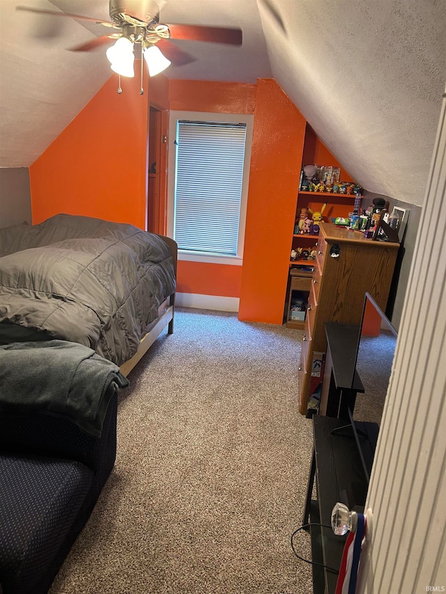 bedroom with lofted ceiling, ceiling fan, carpet floors, and a textured ceiling