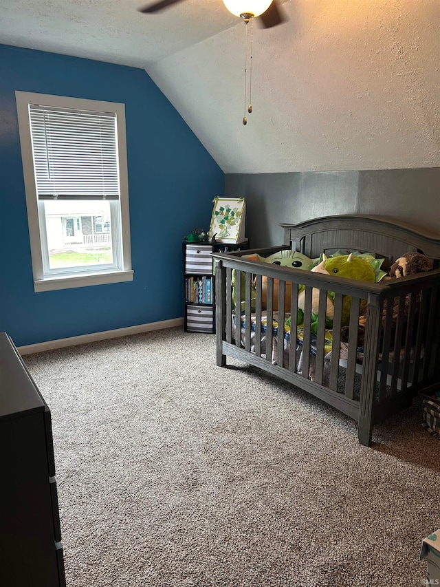 bedroom featuring a textured ceiling, carpet flooring, vaulted ceiling, and ceiling fan