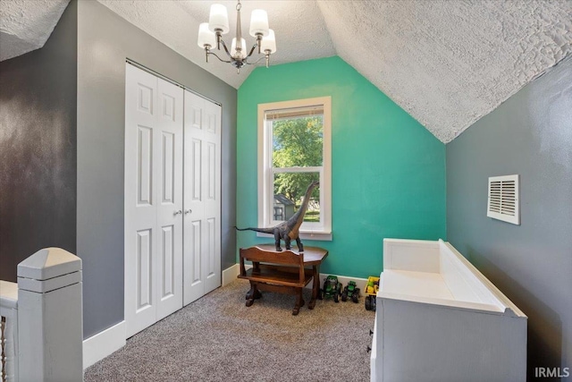 bedroom with lofted ceiling, a closet, a textured ceiling, and carpet floors