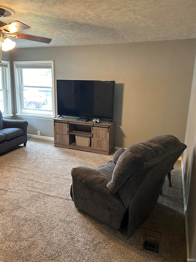 living room featuring a textured ceiling, ceiling fan, and carpet floors