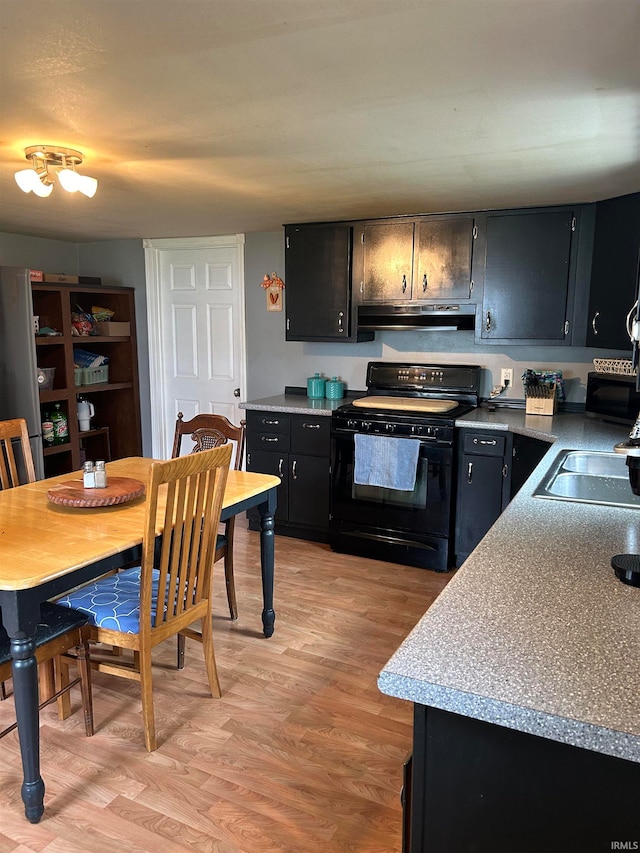 kitchen with light hardwood / wood-style flooring, black range, and sink